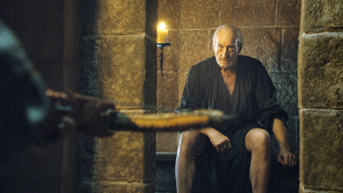 Tywin Lannister sits on a toilet and stares at his son, Tyrion, who is aiming a crossbow at him on 'Game of Thrones.'