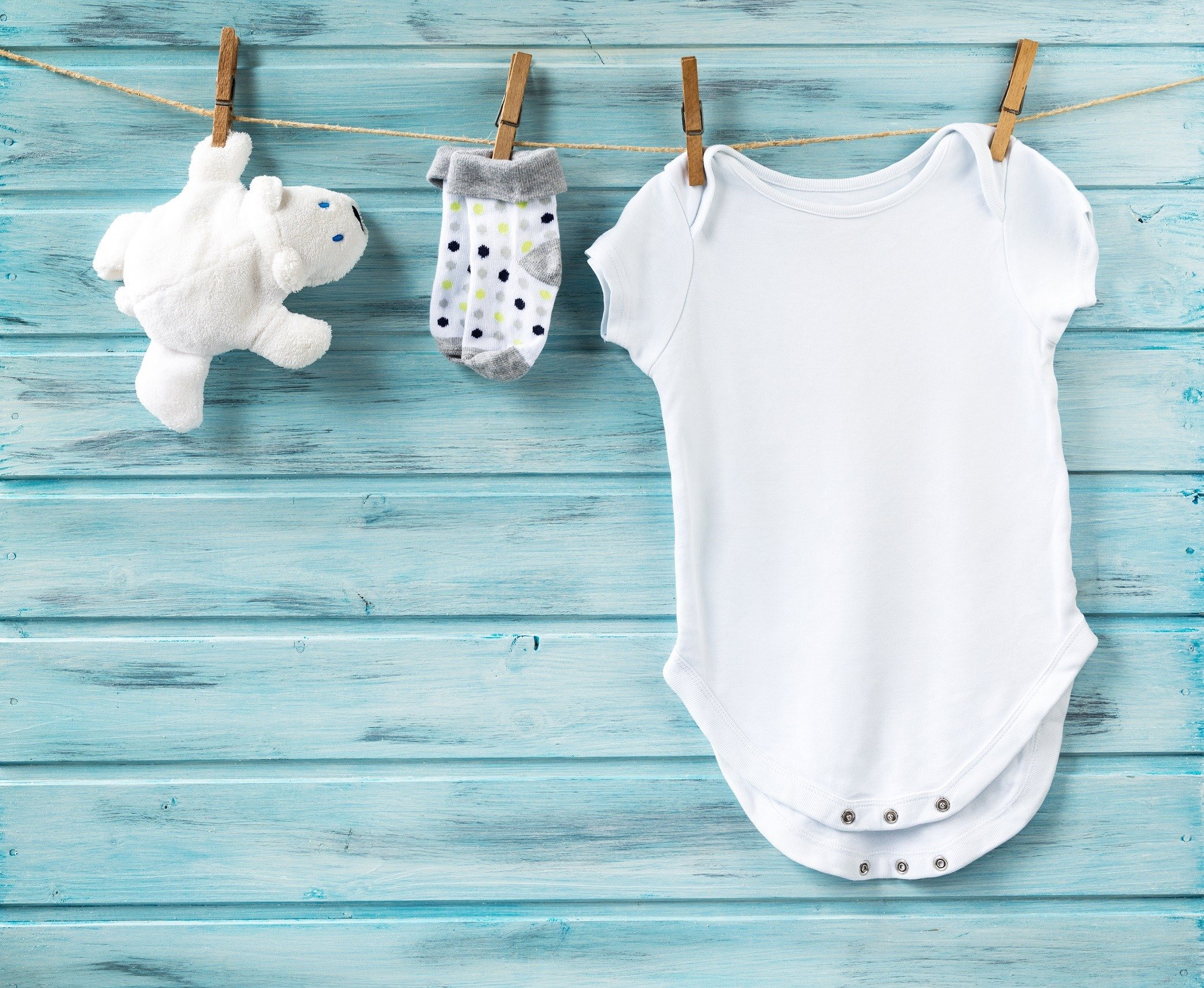 Blue background with white baby onesie and sock