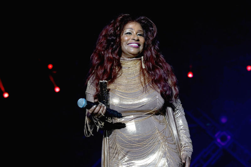 Chaka Khan holding a microphone while on stage. Chaka Khan holding a microphone while on stage.