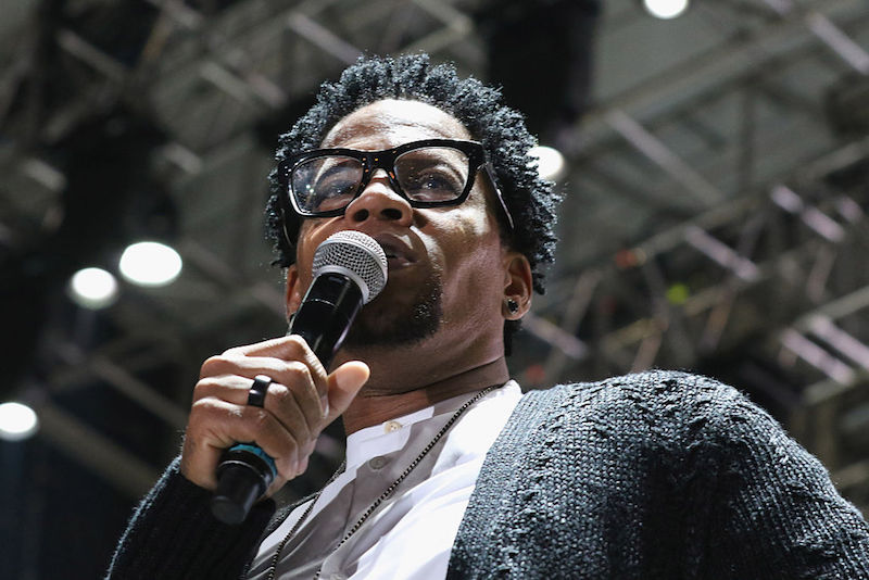 D.L. Hughley holds a microphone while speaking at a music event in Florida.