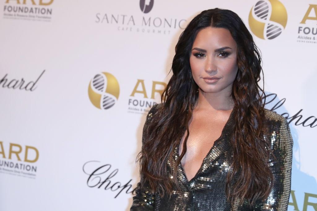 Singer Demi Lovato poses in a shiny dress