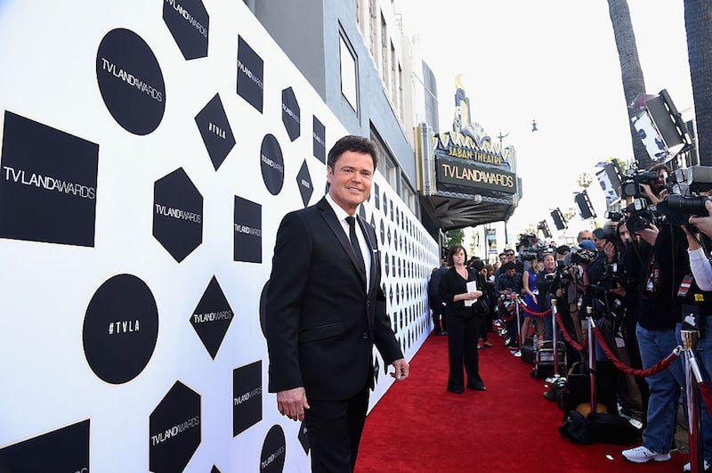 Donny Osmond poses in a tux on the red carpet. Donny Osmond poses in a tux on the red carpet.
