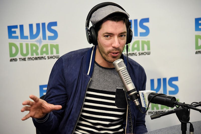 Drew Scott wears a headset and speaks into a mic while appearing on a radio talk show.
