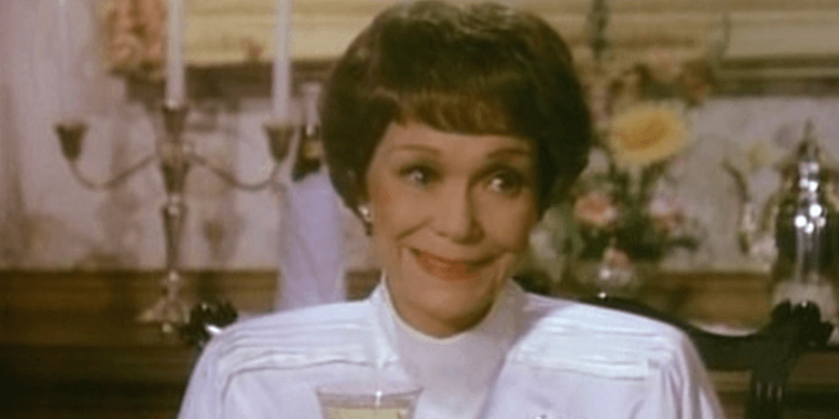 Jane holds a wine glass as she smiles while at the table. Jane holds a wine glass as she smiles while at the table.