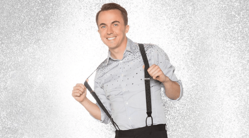 Frankie Muniz holds his suspenders and smiles