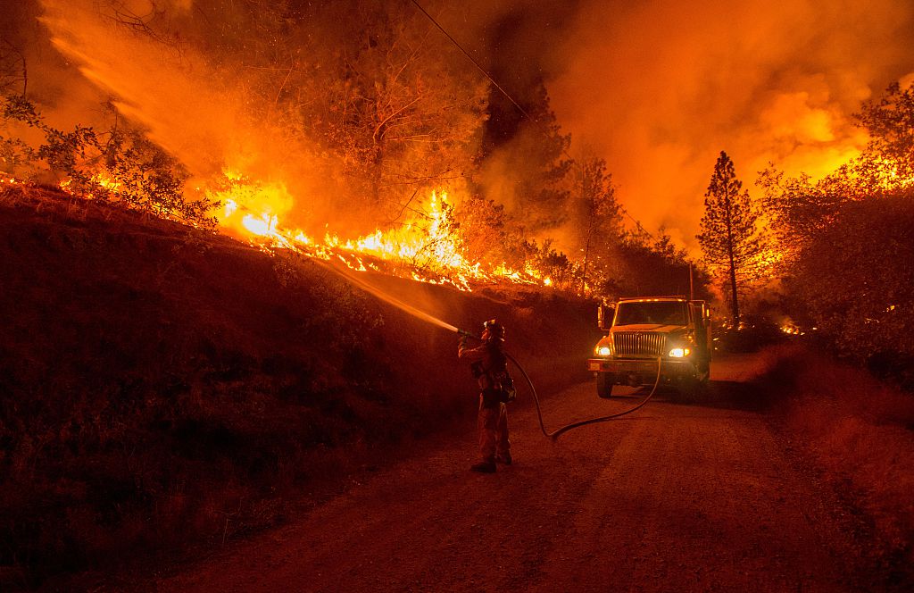 A firefighter douses flames from a backfire while battling the Butte fire near San Andreas, California on September 12, 2015.
