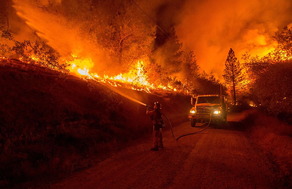 A firefighter douses flames from a backfire while battling the Butte fire near San Andreas, California on September 12, 2015. A firefighter douses flames from a backfire while battling the Butte fire near San Andreas, California on September 12, 2015.