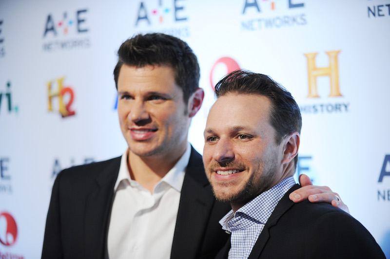 Nick Lachey and Drew Lachey stand next to each other in suits
