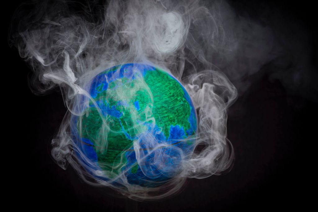 A picture taken on November 10, 2015 shows a small globe surrounded by smoke to illustrate global warming. | LIONEL BONAVENTURE/AFP/Getty Images) A picture taken on November 10, 2015 shows a small globe surrounded by smoke to illustrate global warming.