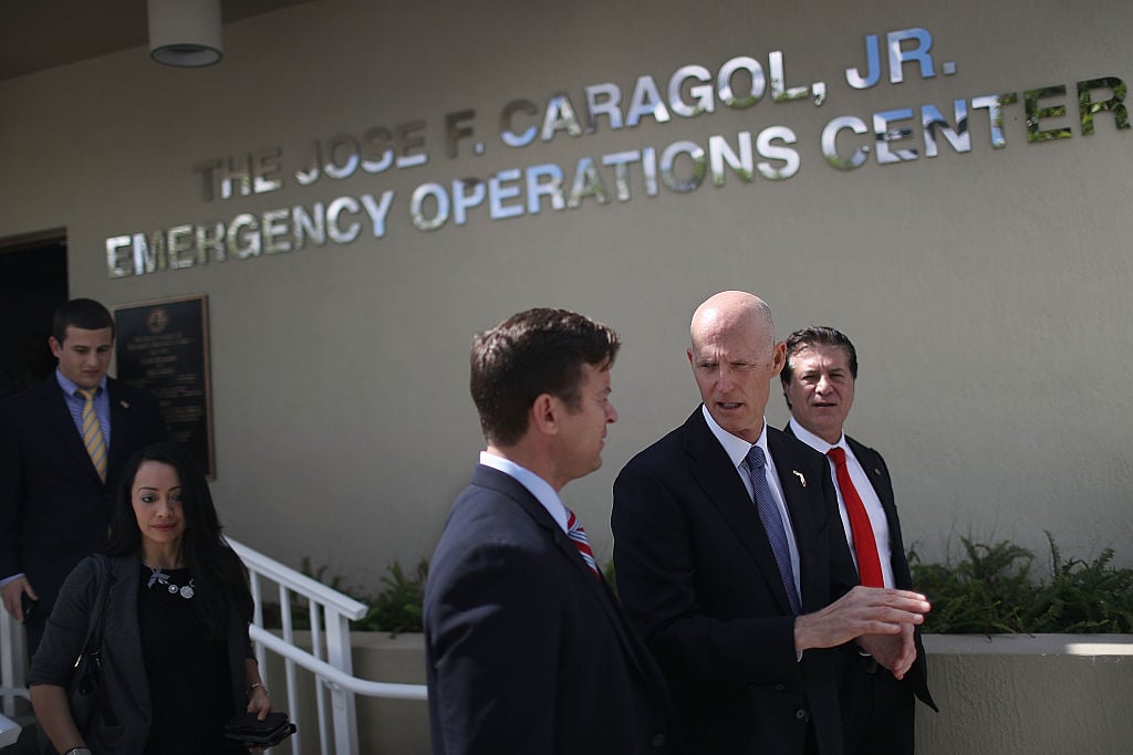 Florida Governor Rick Scott walks with other politicians as he stops by the Jose F. Caragol Jr. Emergency Operations Center on the first day of Hurricane season on June 1, 2016