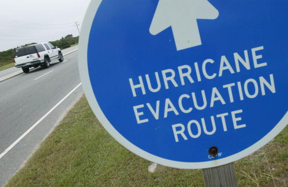 An SUV Drives by a sign that states "Evacuation Route." An SUV Drives by a sign that states "Evacuation Route."