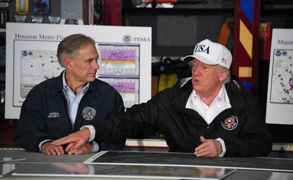 US President Donald Trump (R) sits with Texas Governor Greg Abbott during a briefing on Hurricane Harvey in Corpus Christi, Texas