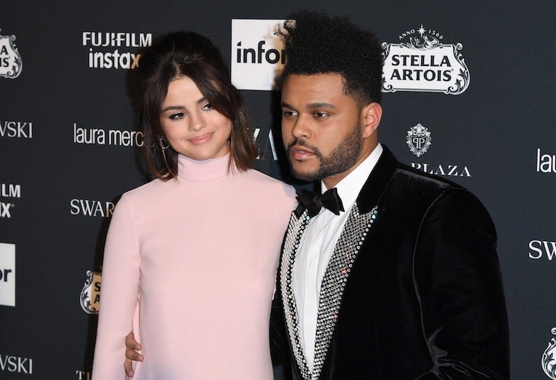 Selena Gomez and The Weeknd pose at an event