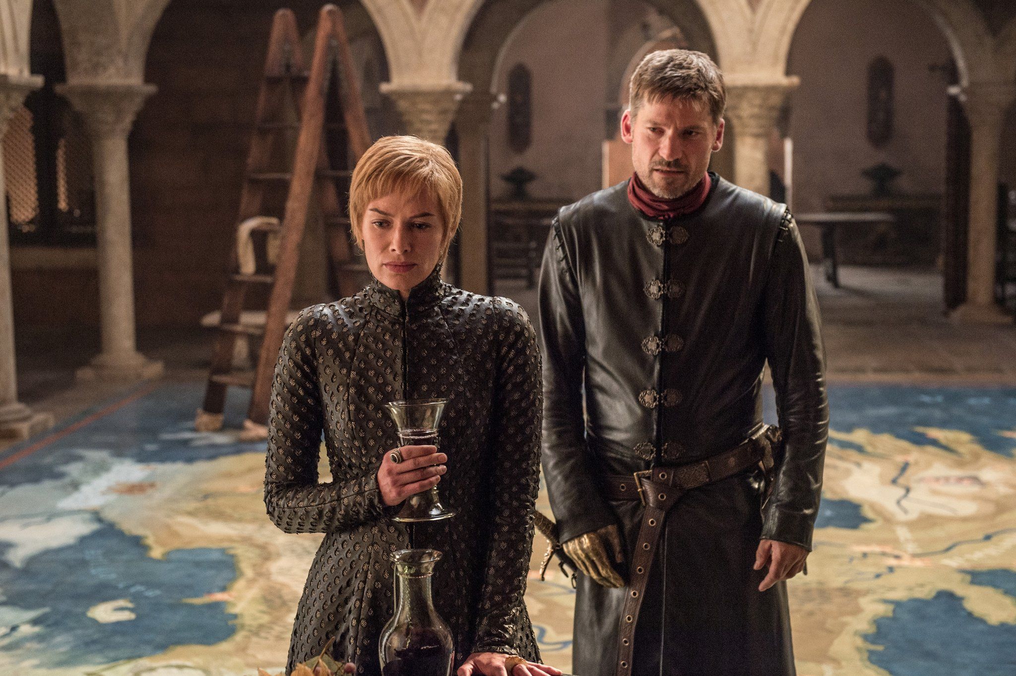 Cersei holds a glass and stands next to Jaime Lannister 