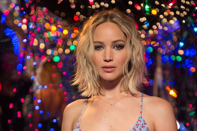 Jennifer Lawrence standing in front of colorful lights. 