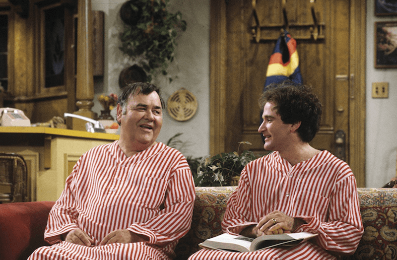 Mork and Mearth sit on a couch wearing red and white striped outfits.