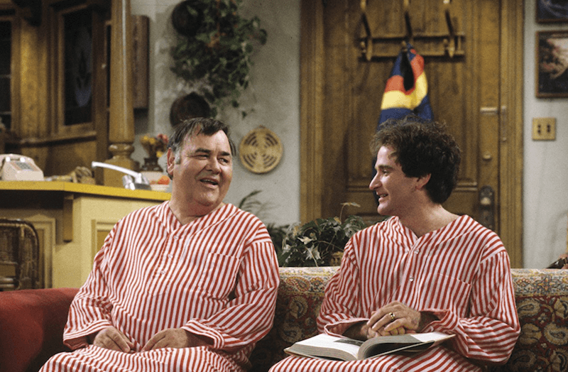 Mork and Mearth sit on a couch wearing red and white striped outfits. Mork and Mearth sit on a couch wearing red and white striped outfits.