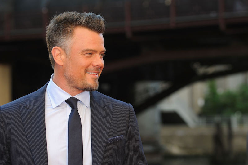 Josh Duhamel in a black striped suit turning to the side. Josh Duhamel in a black striped suit turning to the side.