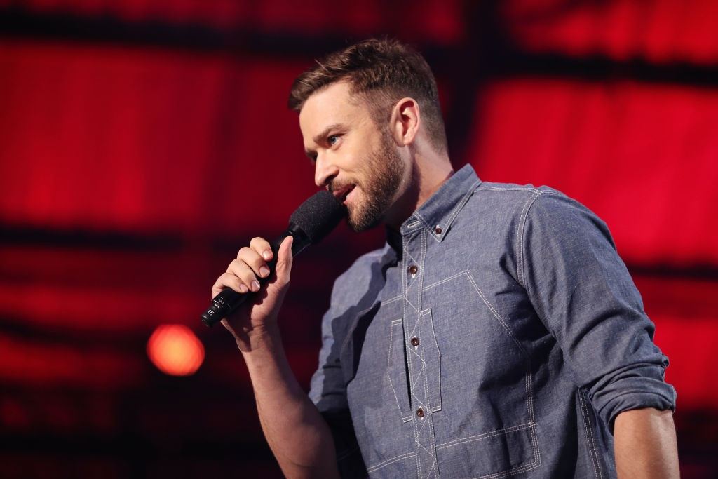 Justin Timberlake speaks into a microphone on stage. Justin Timberlake speaks into a microphone on stage.