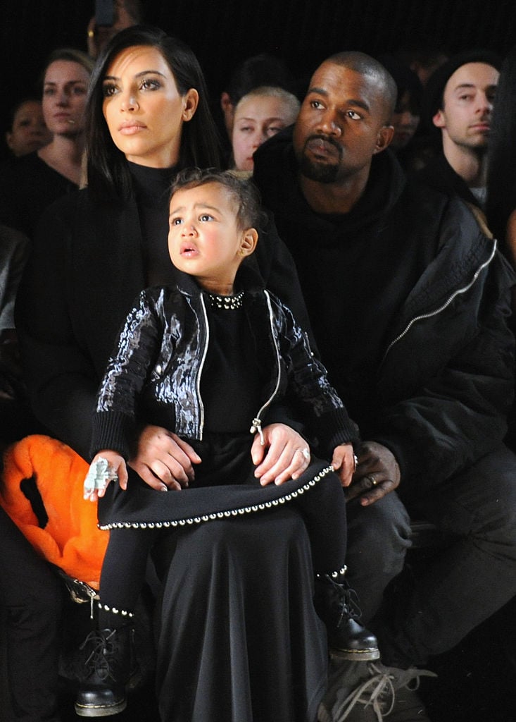 Kim Kardashian, Kanye West, and daughter North West Kim Kardashian and family at a fashion show