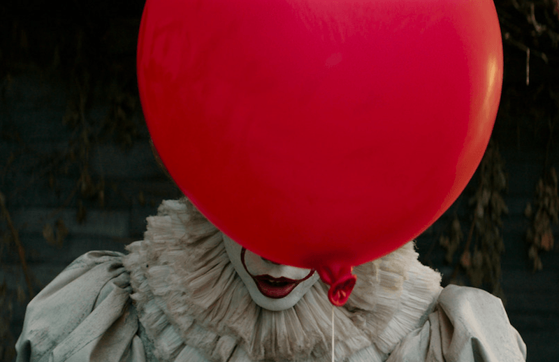 Pennywise behind the iconic red balloon