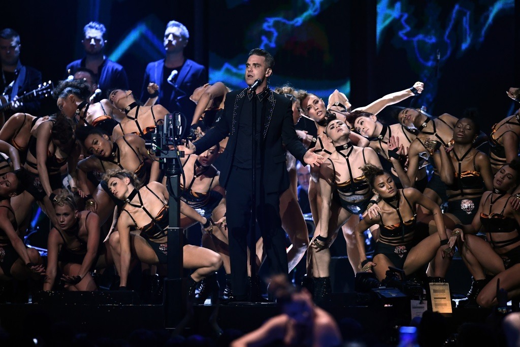 Robbie Williams performing on stage. Robbie Williams performing on stage.