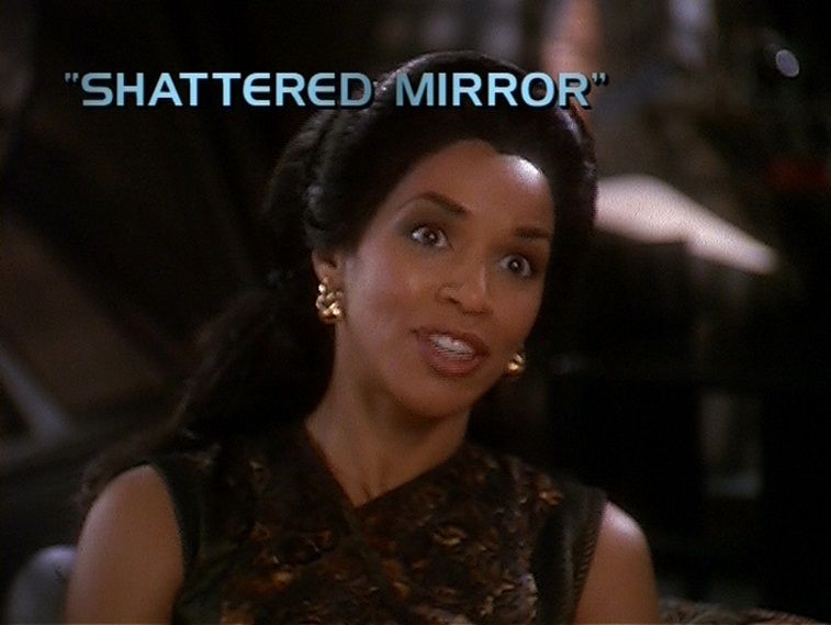 A woman looks ahead with the words "Shattered Mirror" above her head A woman looks ahead with the words "Shattered Mirror" above her head