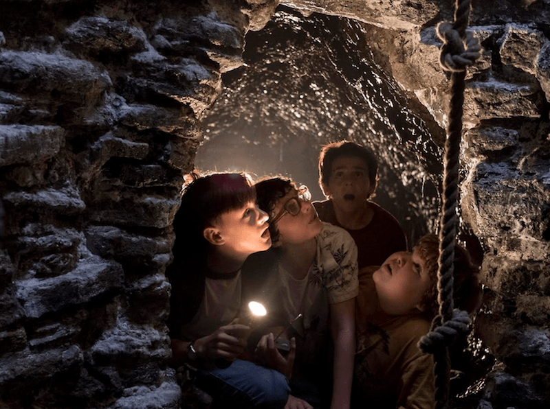 A group of kids looks up at a rope. A group of kids looks up at a rope.
