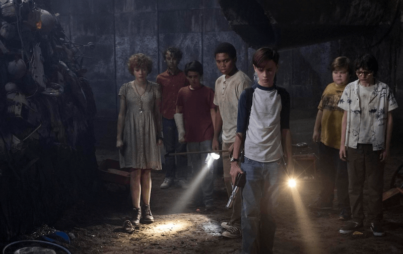 The group of kids hold flashlights while looking forward. The group of kids hold flashlights while looking forward.