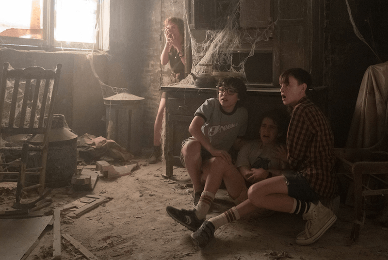 A group of kids huddle in a corner of an abandoned house. A group of kids huddle in a corner of an abandoned house.