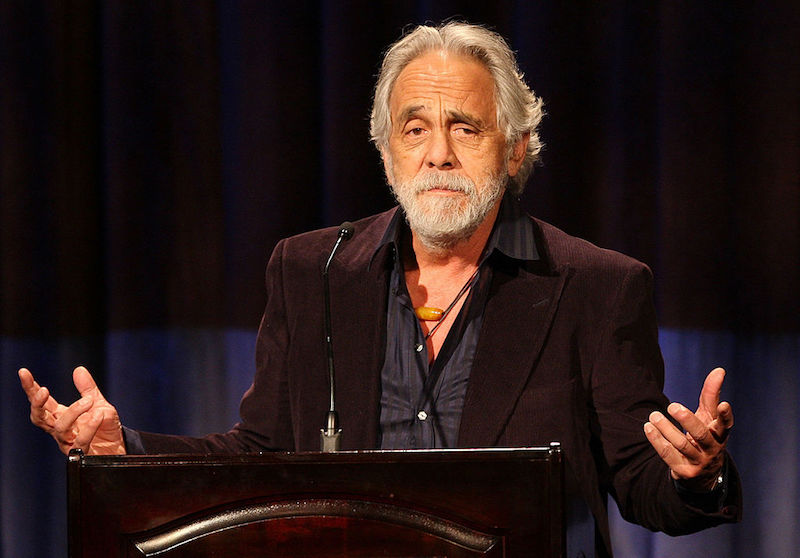 Tommy Chong holds his hands up while speaking at an event in Beverly Hills.