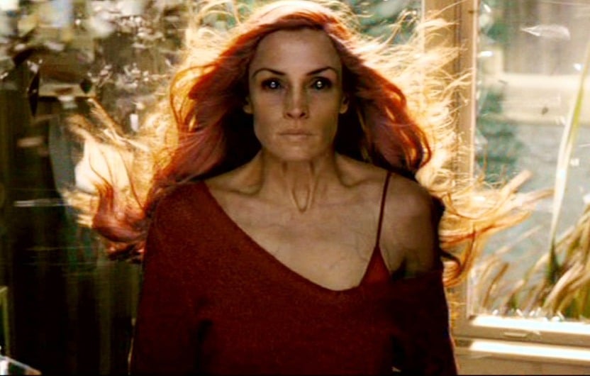 Jean Grey looks straight ahead while her red hair blows in the window