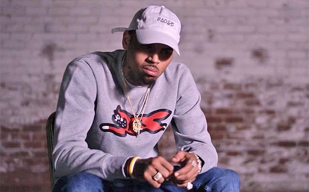 Chris Brown sits in a chair and looks down Chris Brown sits in a chair and looks down