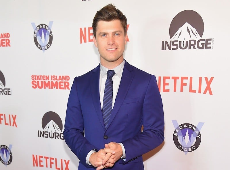 Colin Jost poses in a blue suit at a Netflix event