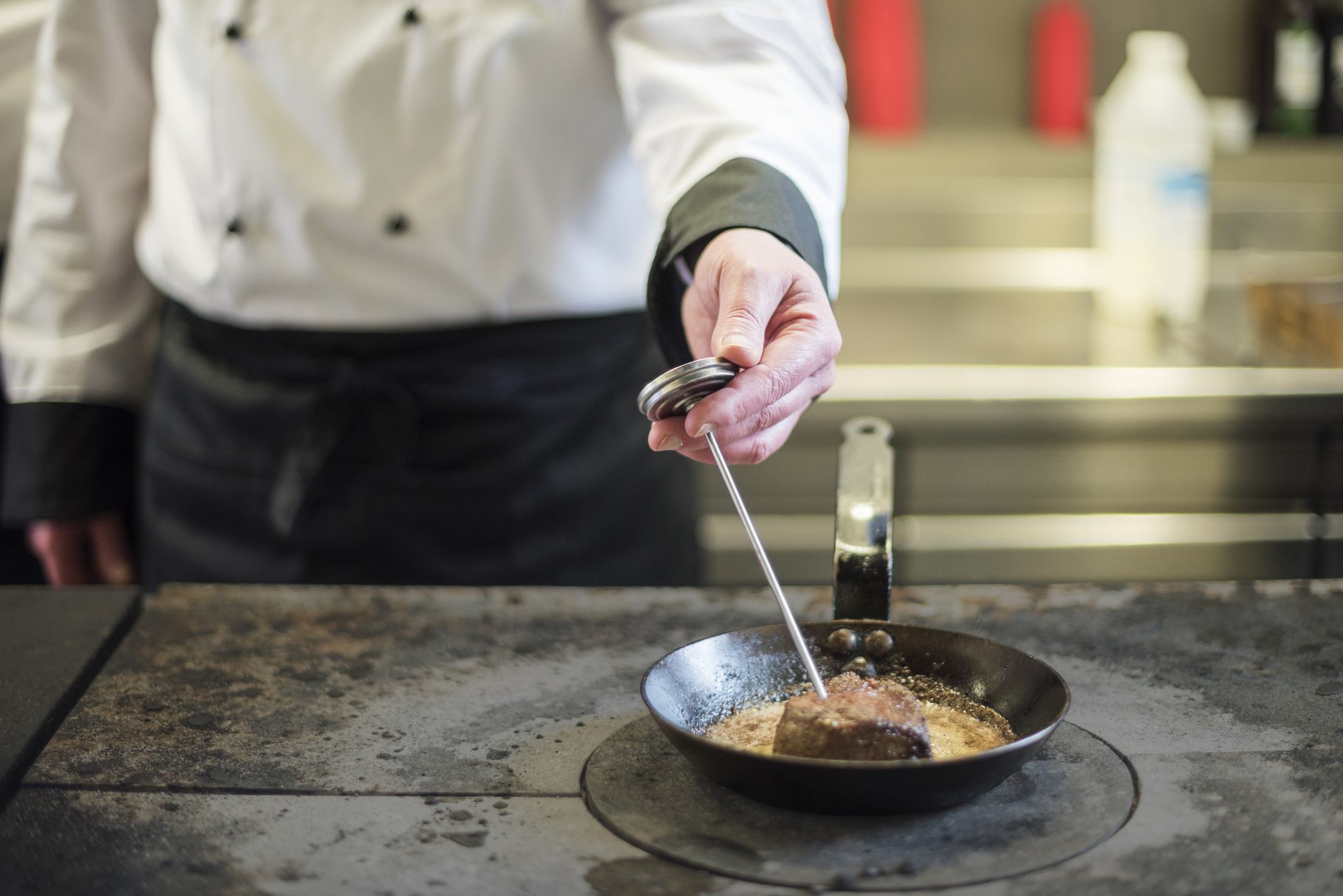 Cook taking temperature of meat