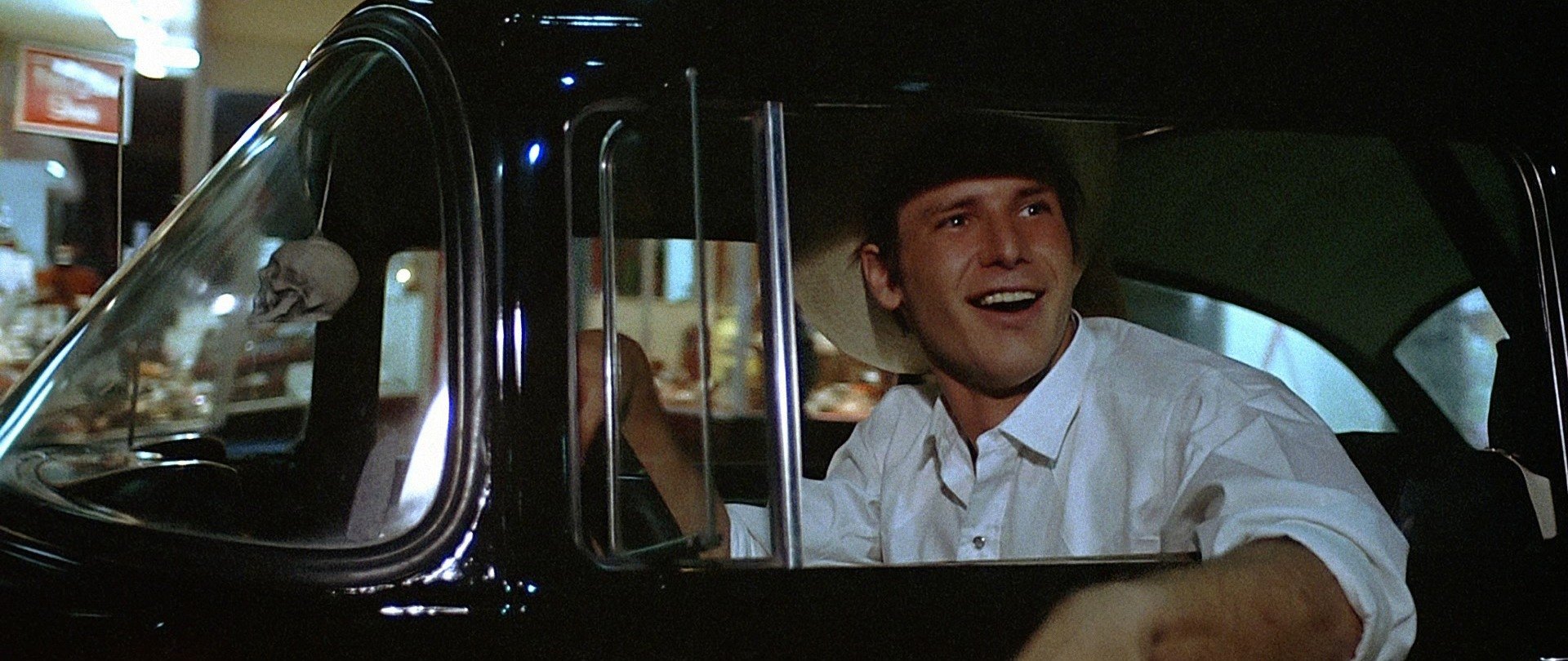 Harrison Ford sits in the driver's seat as Bob Falfa in American Graffiti
