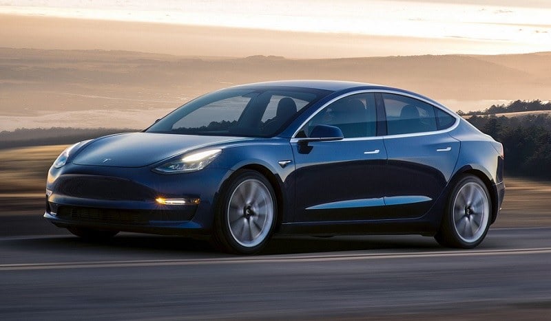 Profile view of Tesla Model 3 in motion on California road