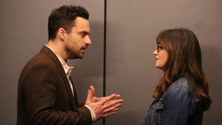 Nick presses his hands together while talking to Jess in front of doors Nick presses his hands together while talking to Jess in front of doors