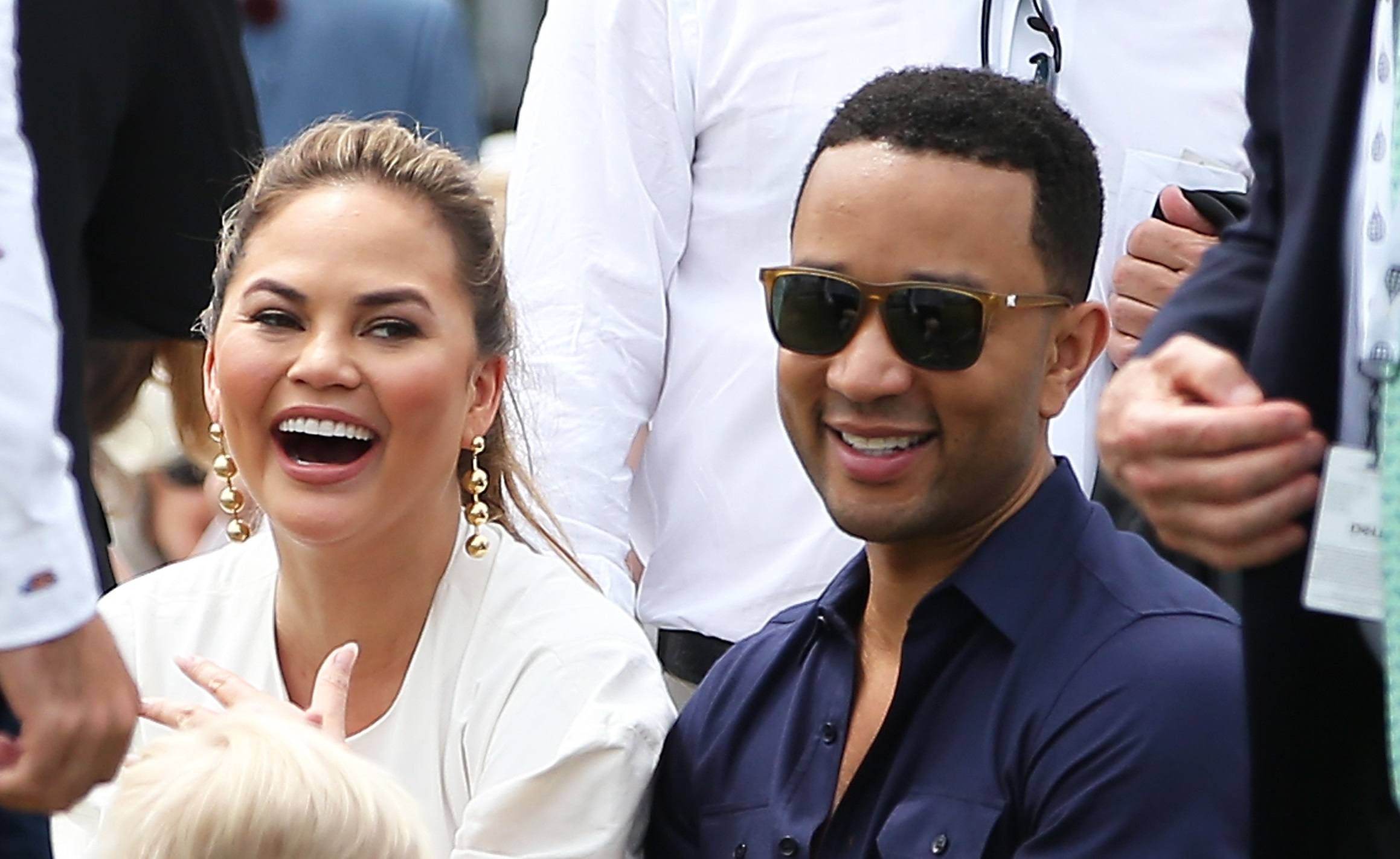 John Legend and Chrissy Teigen look on during the Tennis Hall of Fame induction ceremonies at the International Tennis Hall of Fame on July 22, 2017 in Newport, Rhode Island.