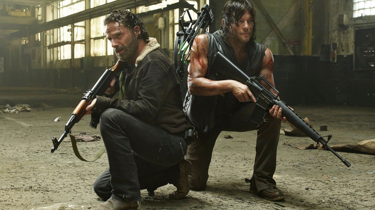 Daryll and Rick holding weapons together. 