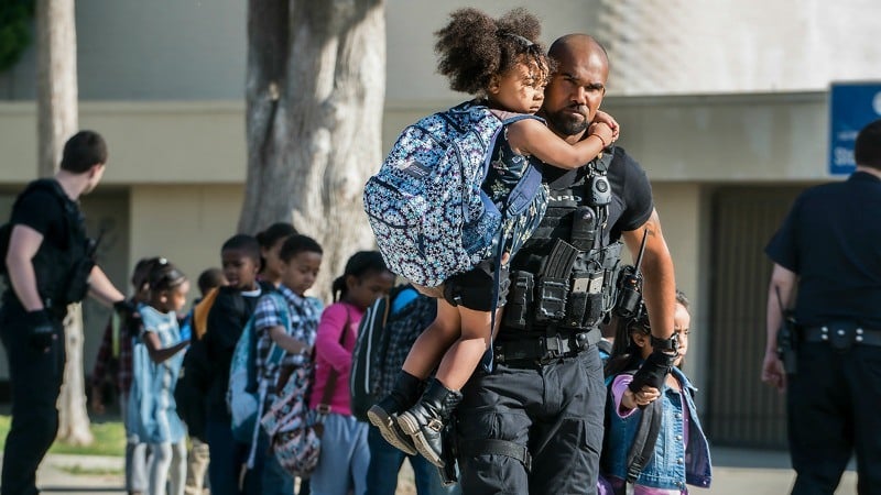 A man lifts a young girl wearing a backpack A man lifts a young girl wearing a backpack