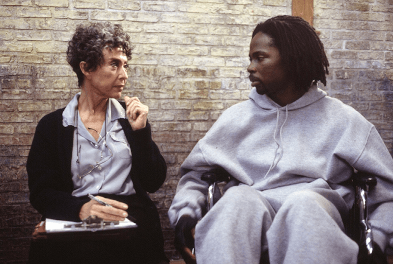 Augustus Hill and Sister Peter Marie Reimondo sitting together and talking while she writes notes in a clipboard. Augustus Hill and Sister Peter Marie Reimondo sitting together and talking while she writes notes in a clipboard.