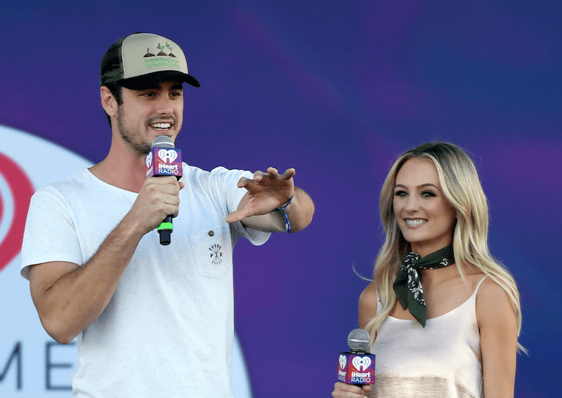 Ben Higgins and Lauren Bushnell standing next to each other as they hold microphones.