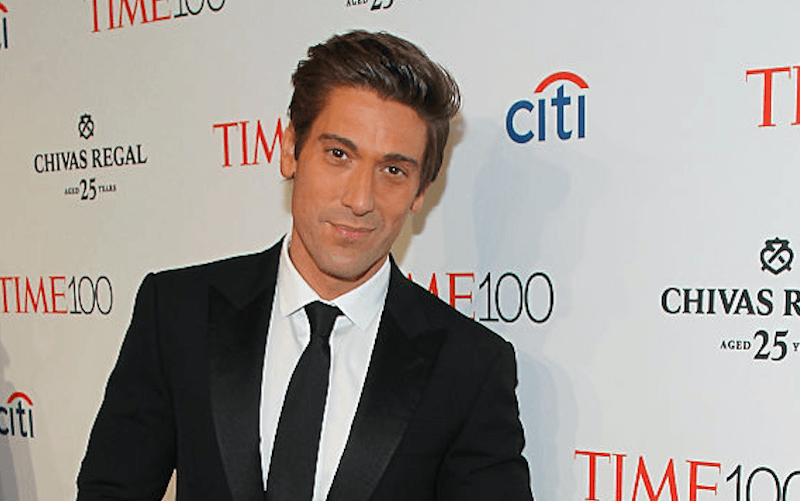 David Muir stands in a black suit and tie while posing for photos on the red carpet. David Muir stands in a black suit and tie while posing for photos on the red carpet.