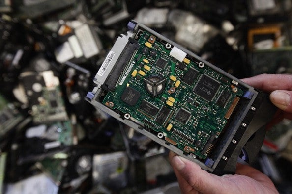 a computer hard drive in front of scrap metal a computer hard drive in front of scrap metal