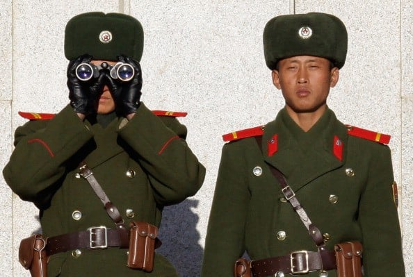 two North Korea guards in green uniforms with binoculars
