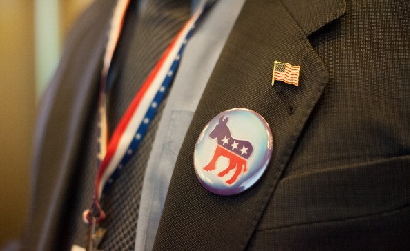 a donkey Democrat badge and American flag lapel pin on a dark suit jacket and a red, white and blue lanyard a donkey Democrat badge and American flag lapel pin on a dark suit jacket and a red, white and blue lanyard