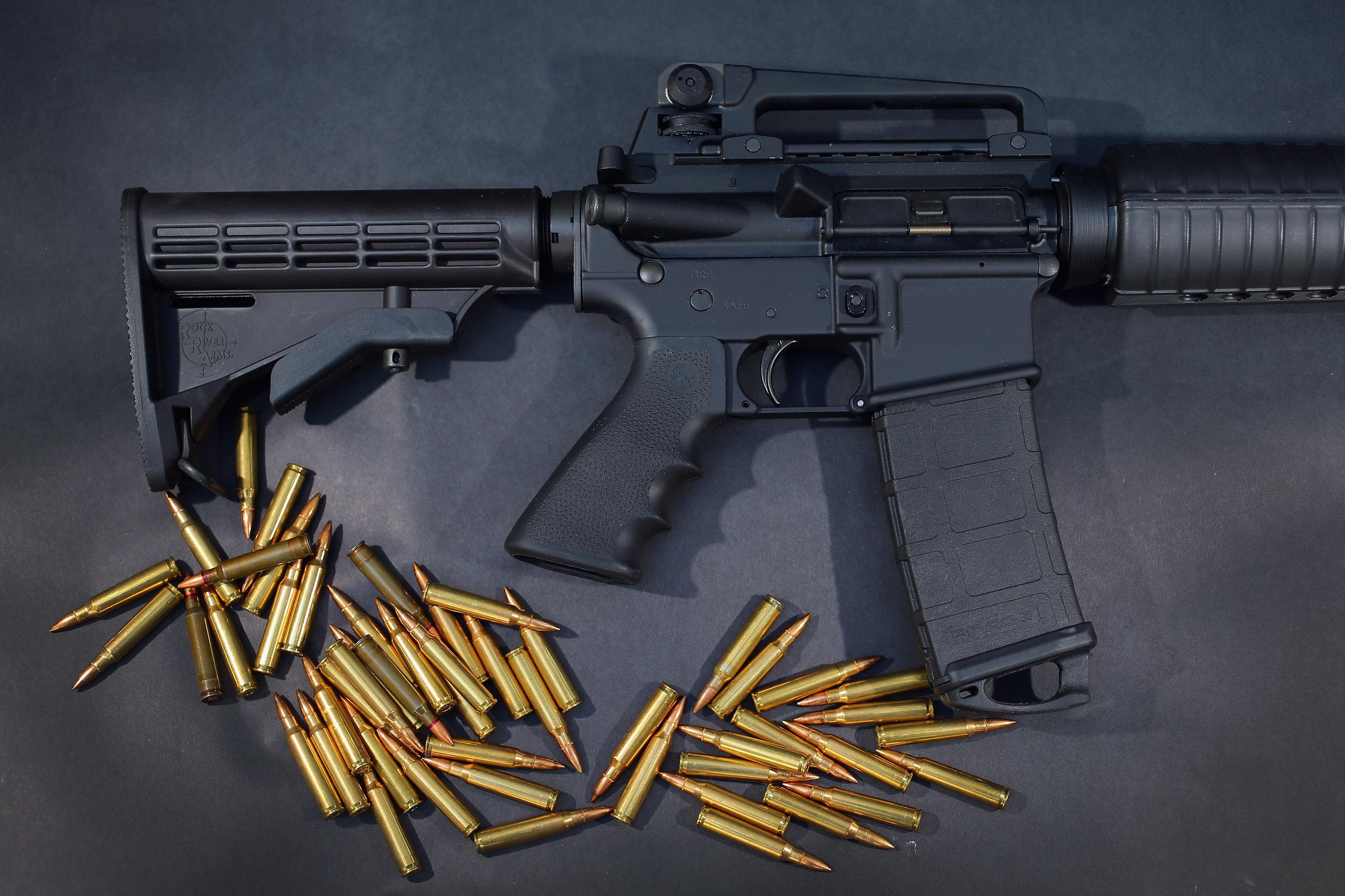 an AR-15 rifle with ammunition on black background an AR-15 rifle with ammunition on black background