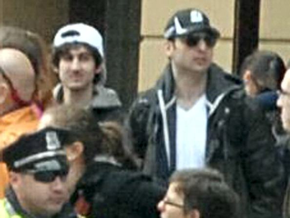 two Boston bombing suspects in a crowd behind a policeman two Boston bombing suspects in a crowd behind a policeman