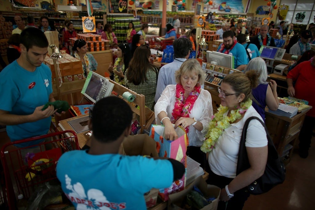 Kimberly Davison (L) and Elena Evans pay for their groceries as they attend the grand opening of a Trader Joe's on October 18, 2013 in Pinecrest, Florida. Trader Joe's opened its first store in South Florida where shoppers can now take advantage of the California grocery chains low-cost wines and unique items not found in other stores. About 80 percent of what they sell is under the Trader Joe's private label. (Photo by Joe Raedle/Getty Images)